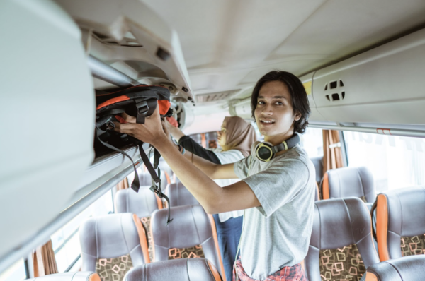 joven subiendo su equipaje al autobus