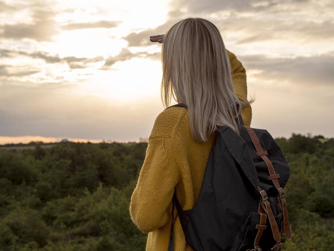 mujer que viaja sola viendo al horizonte 